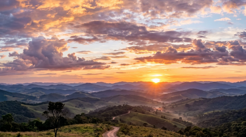 Rolling hills and a winding dirt road under a vibrant sunset sky with clouds